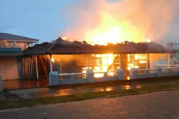 Imóvel de Edmilson Gomes Ogando, no Centro de Balneário Pinhal, estava vazio. Há suspeita de 

que arrombadores tenham provocado o fogo na casa de madeira. Polícia Civil investigará o caso