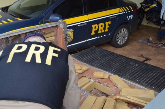 Policial retira droga do fundo falso da caminhonete