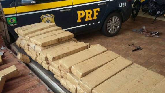Policial retira droga do fundo falso da caminhonete