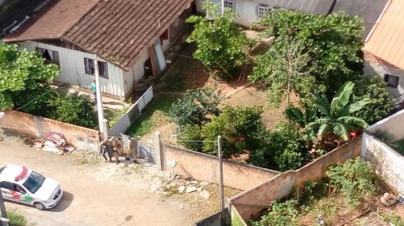 Eles amarraram família e levaram carro, dinheiro e outros objetos, segundo PM. Um policial foi atingido de raspão por um disparo