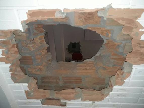 Bandidos entraram em casa que estava desabitada e abriram buraco na parece para acessar agência bancária. Eles conseguiram fugir com armas dos 

vigilantes