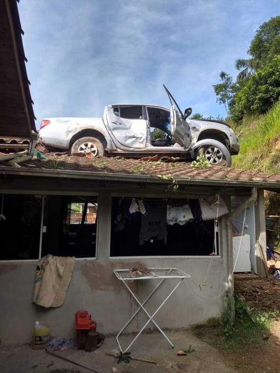 Motorista se perdeu em estrada, caiu de barranco e parou em cima da casa em Orleans. Ele foi para hospital e Defesa Civil foi acionada por risco de desabamento do telhado
